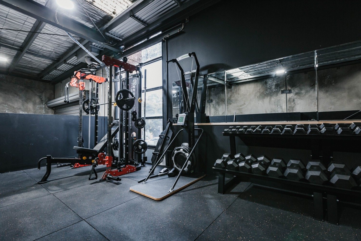 Strength room — racks, ski-erg, and dumbbells